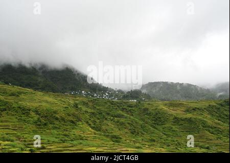 Mountain Province, Philippinen: Abgelegene Gemeinde auf den Sagada Reisterrassen. Berg an einem düsteren Tag in ätherischen Nebel gehüllt. Stockfoto