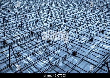 Vorgefertigte Rahmen für Stahlbetonpfähle. Die metallischen Rippenstangen der Verstärkung sind mit Stahldraht verbunden. Zuvor installierte Käfige für die Bevorhaltung von Halterungen Stockfoto
