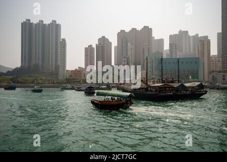 Boote auf dem Wasser im Hafen von Aberdeen, Hongkong, zeigen den Lebensstil der Einheimischen vor dem Hintergrund des modernen Lebens. Stockfoto