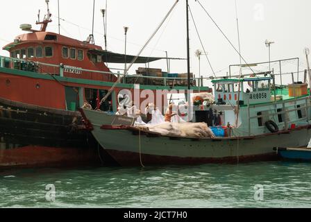 Fischer hüten ihre Netze auf einem Boot im Hafen von Aberdeen, Hongkong. Stockfoto