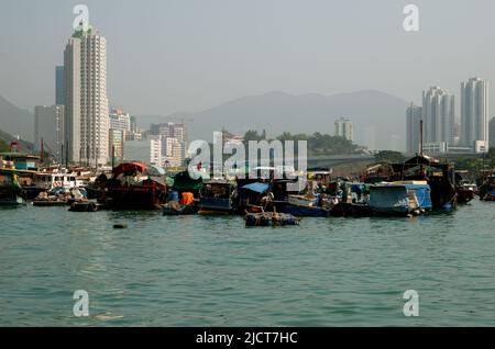Boote auf dem Wasser im Hafen von Aberdeen, Hongkong, zeigen den Lebensstil der Einheimischen vor dem Hintergrund des modernen Lebens. Stockfoto