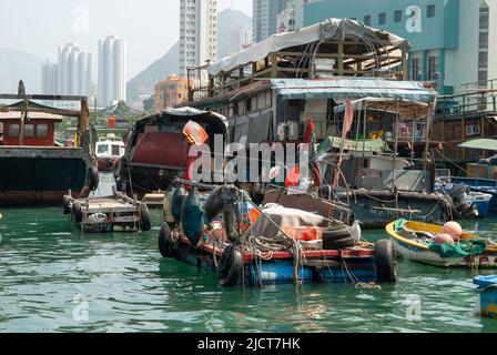 Boote auf dem Wasser im Hafen von Aberdeen, Hongkong, zeigen den Lebensstil der Einheimischen vor dem Hintergrund des modernen Lebens. Stockfoto