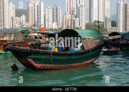 Boote auf dem Wasser im Hafen von Aberdeen, Hongkong, zeigen den Lebensstil der Einheimischen vor dem Hintergrund des modernen Lebens. Stockfoto