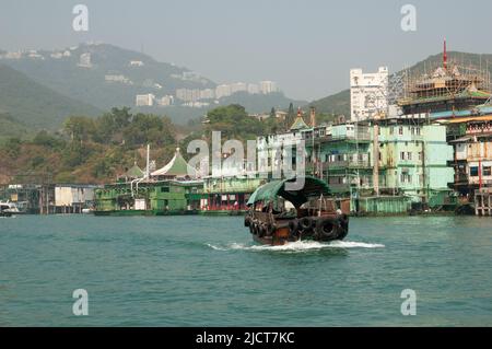 Boote auf dem Wasser im Hafen von Aberdeen, Hongkong, zeigen den Lebensstil der Einheimischen vor dem Hintergrund des modernen Lebens. Stockfoto