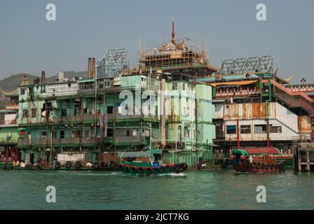 Boote auf dem Wasser im Hafen von Aberdeen, Hongkong, zeigen den Lebensstil der Einheimischen vor dem Hintergrund des modernen Lebens. Stockfoto