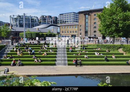 London, Großbritannien. 15.. Juni 2022. Die Menschen sonnen sich auf der grünen Treppe am Granary Square neben dem Regent's Canal in King's Cross, während die Temperaturen in der Hauptstadt steigen. (Bild: © Vuk Valcic/SOPA Images via ZUMA Press Wire) Stockfoto