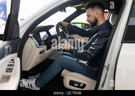 Ein Mann in einem Autohaus wählt ein neues Auto Stockfoto