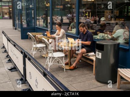 Kunden nutzen am Montag, den 13. Juni 2022, das kostenlose wi-Fi außerhalb der Restaurantkette von Danny Meyer Daily Providerts im Manhattan West Development in New York. (© Richard B. Levine) Stockfoto