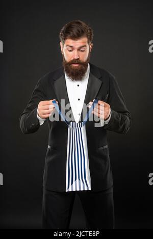 Staunender Mann in Smoking Fliege mit Business-Belohnung in Einkaufstasche. Anlass Gruß. Stockfoto