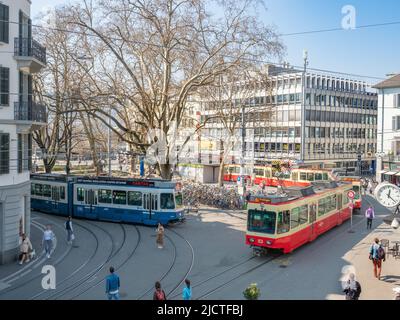 Zürich, Schweiz - März 26. 2022: Blick über den lebhaften Platz mit Straßenbahn vor dem Bahnhof Stadelhofen Stockfoto