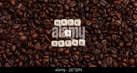 Text - Pause machen - mit Holzbuchstaben auf viele Kaffeebohnen gelegt Stockfoto