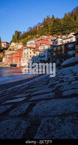 Die kleine Stadt Varenna mit den Lichtern des Sonnenuntergangs: Eines der berühmtesten und besuchten Dörfer des Comer Sees, Italien - Dezember 2021. Stockfoto