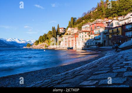 Die kleine Stadt Varenna mit den Lichtern des Sonnenuntergangs: Eines der berühmtesten und besuchten Dörfer des Comer Sees, Italien - Dezember 2021. Stockfoto