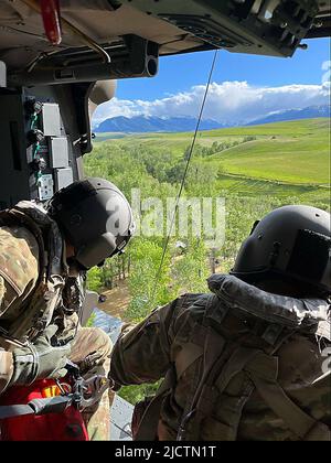 Süd-Montana, USA. 15.. Juni 2022. Auf einem Foto, das von der Nationalgarde von Montana zur Verfügung gestellt wurde, zeigt er, wie Mitglieder der Garde bei der Suche und Rettung helfen. Ein Dutzend Menschen wurden seit Montag in Sicherheit gehisst, sagte die Nationalgarde von Montana am Dienstag. Der Gouverneur von Montana erklärte als Reaktion auf schwere, zerstörerische Überschwemmungen im südlichen Montana und im Yellowstone-Nationalpark eine landesweite Katastrophe. (Bild: © Montana National Guard/ZUMA Press Wire Service) Stockfoto