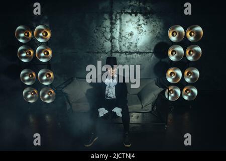 Schwanger Mädchen auf dem Bild eines dicken Mannes vor dem Hintergrund von Lampen in der Dunkelheit Stockfoto