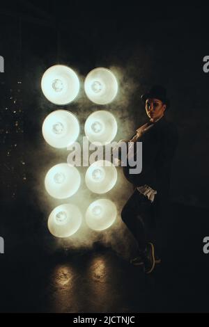 Schwanger Mädchen auf dem Bild eines dicken Mannes vor dem Hintergrund von Lampen in der Dunkelheit Stockfoto