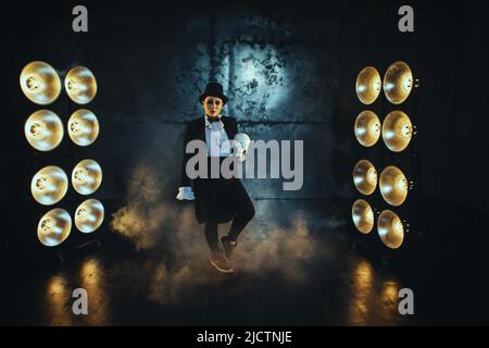 Schwanger Mädchen auf dem Bild eines dicken Mannes vor dem Hintergrund von Lampen in der Dunkelheit Stockfoto