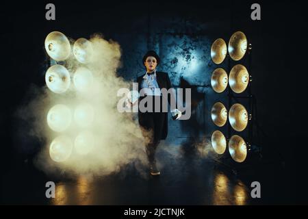 Schwanger Mädchen auf dem Bild eines dicken Mannes vor dem Hintergrund von Lampen in der Dunkelheit Stockfoto