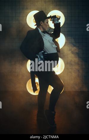 Schwanger Mädchen auf dem Bild eines dicken Mannes vor dem Hintergrund von Lampen in der Dunkelheit Stockfoto