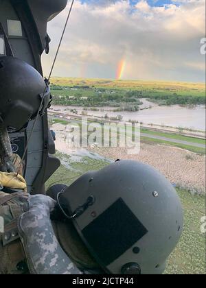 Süd-Montana, USA. 15.. Juni 2022. Auf einem Foto der Nationalgarde von Montana zeigt ein Regenbogen, während Mitglieder der Garde bei der Suche und Rettung helfen. Ein Dutzend Menschen wurden seit Montag in Sicherheit gehisst, sagte die Nationalgarde von Montana am Dienstag. Der Gouverneur von Montana erklärte als Reaktion auf schwere, zerstörerische Überschwemmungen im südlichen Montana und im Yellowstone-Nationalpark eine landesweite Katastrophe. (Bild: © Montana National Guard/ZUMA Press Wire Service) Stockfoto