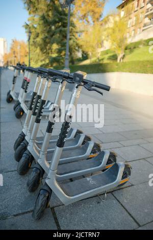 Eine Reihe von geparkten Elektro-Motorroller (E-Scooter). Stockfoto