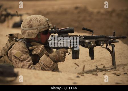 Ein US Marine mit Alpha Company, 1. Bataillon, 8. Marine Regiment, Regiment Combat Team 6 engagiert feindliche Kämpfer mit seinem M249 Kader automatischen mac Stockfoto