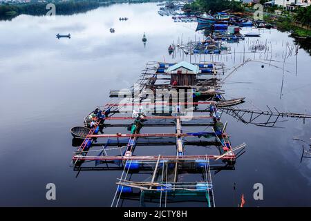 Vietnamesische Fischer bauen eine schwimmende Fischfarm-Struktur, um Garnelen und kleine Fische zu fangen, während die Gezeiten das Wasser auf dem Thu Bon River bewegen. Stockfoto