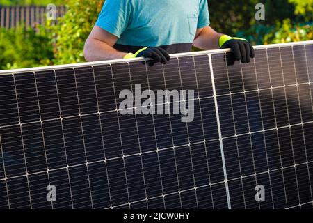 Sonnenenergie.Grüne Energie. Solarpanel in den Händen eines Arbeiters . Montage und Installation von Sonnenkollektoren.Erneuerbare Energien.alternative Energie .Solar Stockfoto