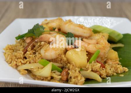 Ananas gebratener Reisteller mit großen Garnelen, großzügigen Gurkenscheiben und verzehrfertig. Stockfoto