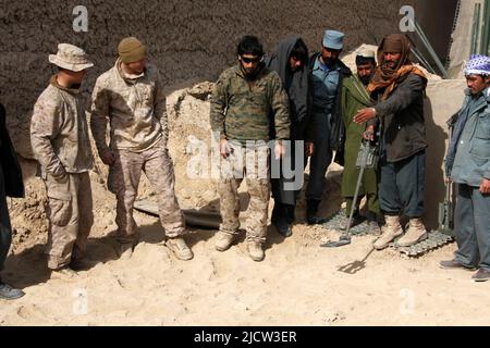 US-Marineinfanteristen mit dem Police Advisory Team 2 (PAT 2) (links), 1. Bataillon, 8. Marine Regiment, Regimental Combat Team 6, beobachten einen uniformierten afghanischen P Stockfoto
