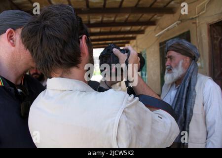 Bernard Smith, links, Reporter, und Ben Foley, Mitte, Kameramann mit Al Jazeera English News Channel interviewt einen afghanischen Lehrer an einer nationalen afghanischen Schule Stockfoto