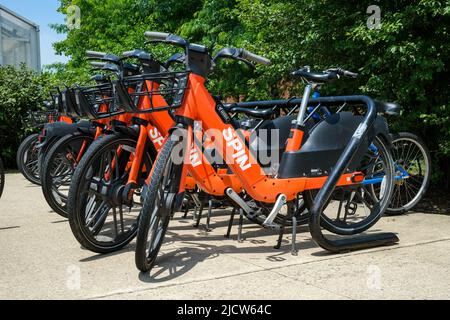 State College, Usa. 15.. Juni 2022. Spin-Elektro-Assistenzräder (E-Bikes) stehen in der Nähe der Berkey Creamery auf dem Campus der Penn State University. Penn State Transportation Services hat sich mit dem Borough of State College und Spin, einem Unternehmen für Mikromobilität im Besitz des Berliner TIER Mobility, zusammen gesetzt, um rund 300 vermietbare E-Bikes auf dem Campus und im Stadtteil bereitzustellen. Kredit: SOPA Images Limited/Alamy Live Nachrichten Stockfoto