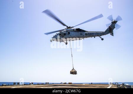 GOLF VON ADEN (9. Juni 2022) ein Helikopter MH-60s Sea Hawk, der an die „Sea Knights“ des Hubschrauber-Seekampfgeschwaders (HSC 22) angeschlossen ist, hebt Fracht während einer vertikalen Trainingsentwicklung an Bord des Küstenkampfschiffs USS Sioux City (LCS 11) im Golf von Aden, 9. Juni. Sioux City wird im Einsatzgebiet der US-Flotte für 5. eingesetzt, um die Sicherheit und Stabilität der Seefahrt in der Region des Nahen Ostens zu gewährleisten. (USA Navy Foto von Mass Communication Specialist 3. Klasse Nichola A. Russell) Stockfoto