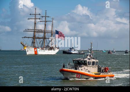 Eine Küstenwache Galveston 45-Fuß-Boot-Medium bietet Sicherheit, während die US-Küstenwache Cutter Barque Eagle den Galveston-Kanal in Richtung Pier 21 in Galveston, Texas, durchfährt, 10. Juni 2022. Der Eagle, der an der Coast Guard Academy in New London, Connecticut, untergebracht ist, wird als Trainingsplattform für zukünftige Küstenwache-Offiziere genutzt und besuchte Galveston, Texas, zum ersten Mal seit 1972. (USA Foto der Küstenwache von Petty Officer, Klasse 2., Ryan Dickinson) Stockfoto