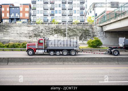 Leistungsstarke rote große Rig Motorhaube Industrie Kipper LKW-Traktor transportieren kommerzielle Fracht in zwei Spitze Anhänger fahren für die Lieferung auf dem breiten Multili Stockfoto