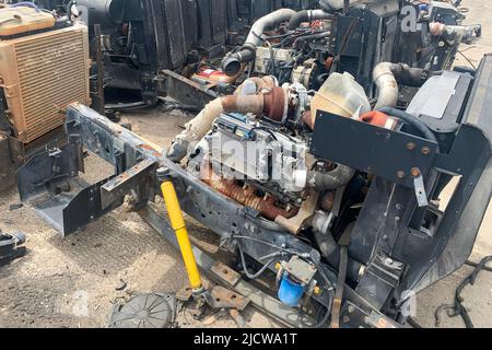 Nahaufnahme des Motors eines defekten LKWs in einer Deponie, des Motors eines zerstörten Autos für Ersatzteile. Stockfoto