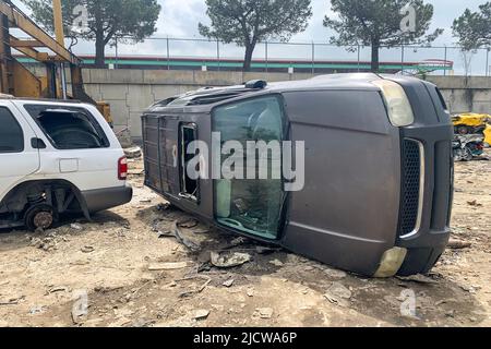 Umgedrehtes Auto auf Schrottplatz, Auto auf Autodumpe nach Unfall, beschädigtes Fahrzeug auf Schrottplatz, Recycling von alten, gebrauchten, zerstörten Autos Stockfoto