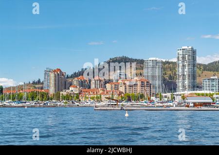 Ein Blick auf die Kelowna Skyline und Okanagan Lake British Columbia Canada im Sommer. Stadtbild am sonnigen Sommertag. Kelowna Boardwalk. Reisefoto, Stockfoto