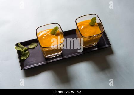 Mango-Smoothie oder im Glas auf weißem Hintergrund schütteln. Draufsicht, selektiver Fokus. Stockfoto
