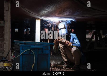 16. Juni 2022, Dhaka, Dhaka, Bangladesch: Mechaniker schweißen ein Schiff an einer Werft in Keraniganj am Stadtrand von Dhaka, Bangladesch. Mit Dutzenden von Werften scheint Keraniganj am Ufer des Flusses Burigonga, der an den südwestlichen Außenbezirken der Hauptstadt Dhaka in Bangladesch vorbeifließt, jetzt ein Megazentrum für den Bau und die Reparatur kleiner Schiffe, Starts und Dampfschiffe zu sein. Das Gebiet schläft nie mit Hunderten von Arbeitern, die die Frachtschiffe und Kreuzer demontieren, die nicht mehr verwendet werden, um ihre Teile in neuen oder reparierten Teilen rund um die Uhr wiederverwenden zu können.Es gibt mehr als 35 Werften in Old DhakaÂ''' Keraniganj Gegend vorbei Stockfoto