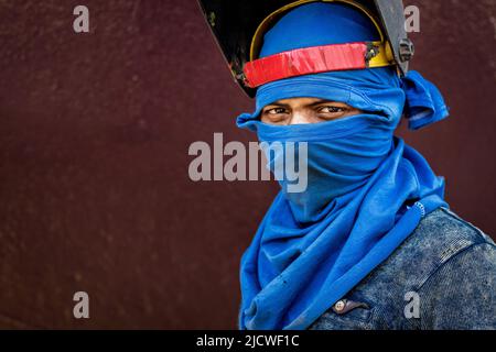 16. Juni 2022, Dhaka, Dhaka, Bangladesch: Ein Arbeiter mit dem Gesicht posiert für ein Bild auf einer Werft in Keraniganj am Stadtrand von Dhaka, Bangladesch. In der Mehrheit der Werften werden den Arbeitnehmern ihre Rechte entzogen. Sie arbeiten unter riskanten Bedingungen, haben aber keinen Zugang zu Sicherheitsausrüstung, Arbeitsplatzsicherheit oder Lebenshaltungslohn. Mit Dutzenden von Werften scheint Keraniganj am Ufer des Flusses Burigonga, der an den südwestlichen Außenbezirken der Hauptstadt Dhaka in Bangladesch vorbeifließt, jetzt ein Megazentrum für den Bau und die Reparatur kleiner Schiffe, Starts und Dampfschiffe zu sein. Die Gegend schläft nie mit Zentner Stockfoto