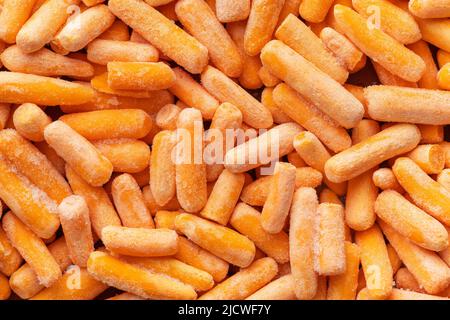 Gefrorenes Baby-Karottengemüse. Mini-orangefarbene Karotten. Draufsicht. Stockfoto
