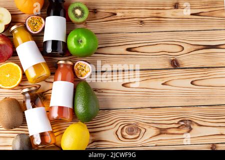 Obst und frisch gepresster Fruchtsaft auf Holztisch Stockfoto