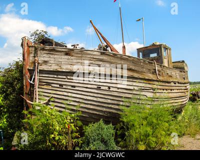 Ein altes verwittertes, hölzernes Fischerboot, das in den Werften von Faversham, England, aufgegeben wurde Stockfoto