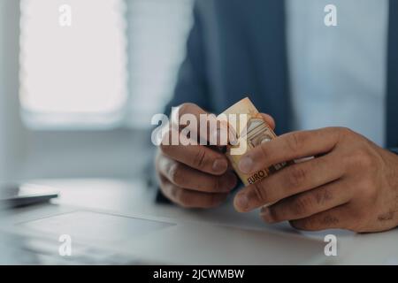 Nahaufnahme eines Geschäftsmannes, der Euro-Geld hält, Inflationskonzept. Stockfoto