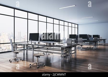 Perspektivischer Blick auf stilvolle, minimalistische Designarbeitsplätze mit modernen Computern auf Holzboden und Blick auf die Stadt vom großen Fenster aus. 3D Rendern Stockfoto