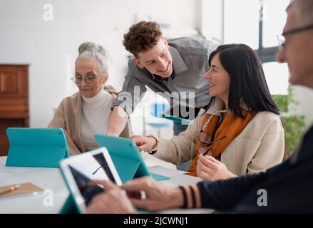 Gruppe von Senioren, die mit dem Lehrer an DER IT-Klasse im Gemeindezentrum teilnehmen Stockfoto