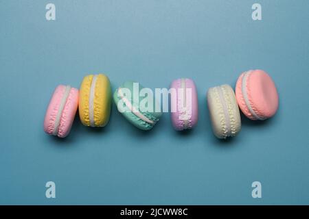 Bunte hausgemachte Makronen auf blauem Hintergrund. Draufsicht. Stockfoto