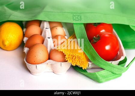 Volle grüne Tüte mit gesunden Lebensmitteln auf weißem Hintergrund. Top Ansicht. Obst, Gemüse, Eier Online-Shop. Ihr Text. Lebensmittel-Lieferung Stockfoto