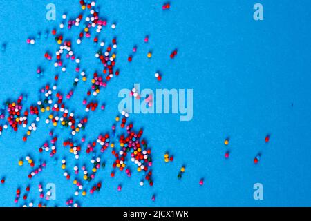 Zucker backen bunte Streuseln in Form von Kreis isoliert auf einem blauen Hintergrund. Urlaubskonzept Stockfoto